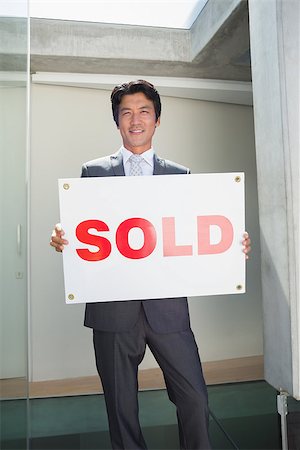 simsearch:693-03308239,k - Confident estate agent standing at front door showing sold sign outside a house Stock Photo - Budget Royalty-Free & Subscription, Code: 400-07483413
