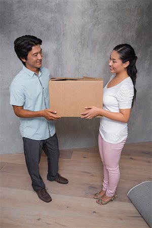 simsearch:400-07927836,k - Happy couple holding a cardboard moving box in their new home Stock Photo - Budget Royalty-Free & Subscription, Code: 400-07483491