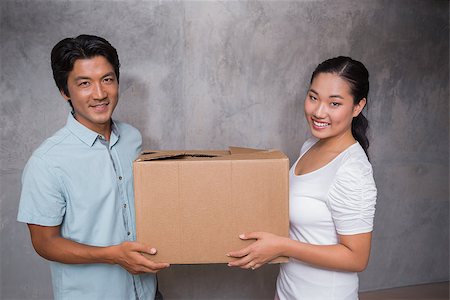 simsearch:400-07927836,k - Happy couple holding a cardboard moving box in their new home Stock Photo - Budget Royalty-Free & Subscription, Code: 400-07483492