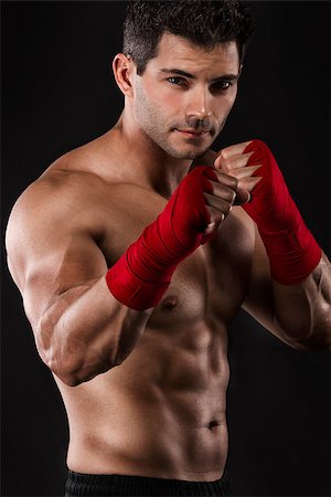 simsearch:400-05908874,k - Portrait of a muscular man practicing body combat against a dark background Stock Photo - Budget Royalty-Free & Subscription, Code: 400-07507540