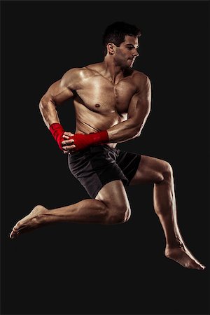 Portrait of a muscular man practicing body combat against a dark background Stock Photo - Budget Royalty-Free & Subscription, Code: 400-07507541