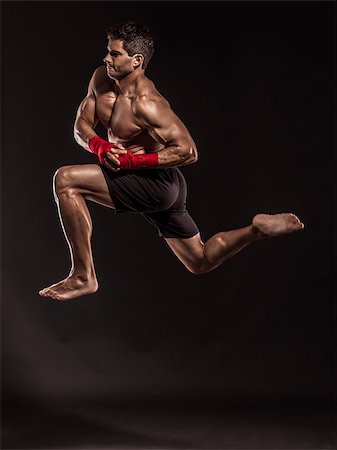 simsearch:400-05908874,k - Portrait of a muscular man practicing body combat against a dark background Stock Photo - Budget Royalty-Free & Subscription, Code: 400-07507542