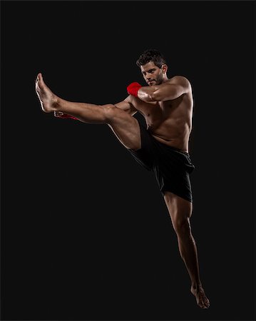 simsearch:400-05908874,k - Portrait of a muscular man practicing body combat against a dark background Stock Photo - Budget Royalty-Free & Subscription, Code: 400-07507543