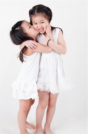 simsearch:400-07171482,k - Little girls portrait. Asian sisters kissing on plain background. Sibling love. Stock Photo - Budget Royalty-Free & Subscription, Code: 400-07518978