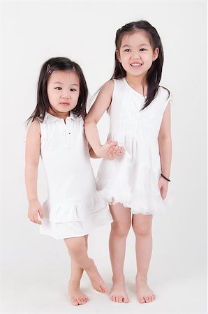 simsearch:400-07171482,k - Little girls portrait. Asian sisters holding hand on plain background. Sibling love. Stock Photo - Budget Royalty-Free & Subscription, Code: 400-07518979