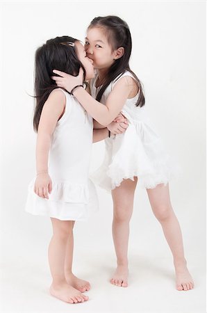 simsearch:400-07171482,k - Little girls portrait. Asian sister kissing sibling on plain background. Stock Photo - Budget Royalty-Free & Subscription, Code: 400-07518980