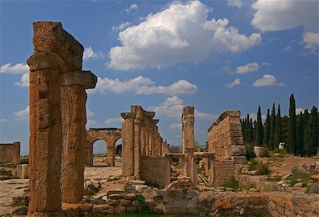 simsearch:400-06642892,k - Hierapolis was an ancient Greco-Roman city and now its ruins are adjacent to modern Pamukkale, Turkey. Residuel arches against the blue sky background are eye-catching. Stock Photo - Budget Royalty-Free & Subscription, Code: 400-07510571