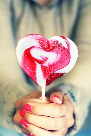 Photo of girl holding heart shaped lollipop Stock Photo - Budget Royalty-Free & Subscription, Code: 400-07549540