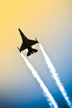 aerobatic military jet in a gradient sky leaving a smoke trail Stock Photo - Budget Royalty-Free & Subscription, Code: 400-07553150