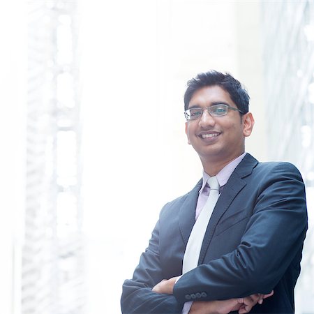 szefei (artist) - Portrait of a good looking smiling Indian businessman crossed arms standing at modern building, with natural light. Stock Photo - Budget Royalty-Free & Subscription, Code: 400-07553696