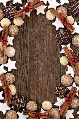 Christmas biscuit food background with cinnamon sticks and red bauble decorations over old oak wood. Photographie de stock - Aubaine LD & Abonnement, Code: 400-07614365