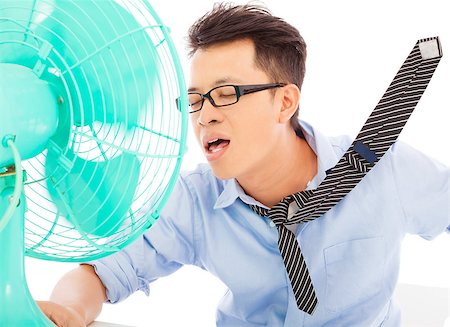 sweaty businessman - Young man cooling face under wind of fan Stock Photo - Budget Royalty-Free & Subscription, Code: 400-07619025