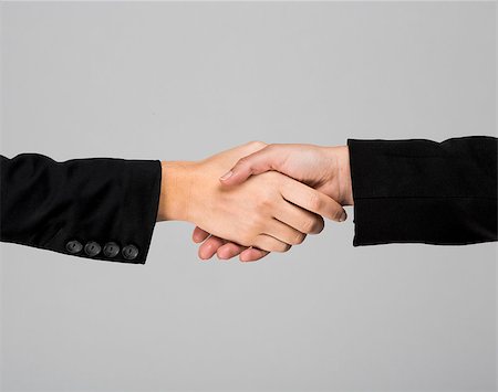 simsearch:400-04609965,k - Hands giving a handshake over a gray background Stock Photo - Budget Royalty-Free & Subscription, Code: 400-07619915