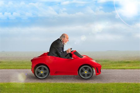 funny images of people driving - senior man in a suit driving a toy racing car Stock Photo - Budget Royalty-Free & Subscription, Code: 400-07626579