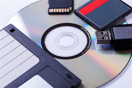 Selection of different computer storage devices for data and information including a CD-DVD, floppy disc, USB key, compact flash card and SD card viewed in a neat arrangement from overhead Stock Photo - Budget Royalty-Free & Subscription, Code: 400-07629924