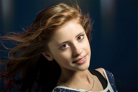 simsearch:400-07509444,k - Studio fashion portrait of young beautiful girl with nice eyes on dark blue background with wind from fan in hair Stock Photo - Budget Royalty-Free & Subscription, Code: 400-07621057