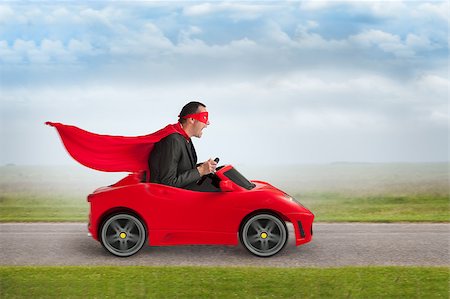 funny images of people driving - superhero man driving a red toy racing car at speed Stock Photo - Budget Royalty-Free & Subscription, Code: 400-07630507