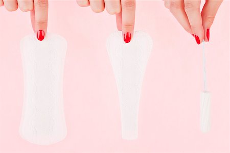 Female hand with red fingernails holding a clean pantyliner, g - string pantyliner and a tampon isolated over pink background. Feminine hygiene concept. Photographie de stock - Aubaine LD & Abonnement, Code: 400-07667140