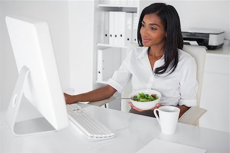 Happy pretty businesswoman eating a salad at her desk in her office Stock Photo - Budget Royalty-Free & Subscription, Code: 400-07662833