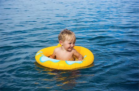 Little boy floats in water on rubber ring Photographie de stock - Aubaine LD & Abonnement, Code: 400-07676951