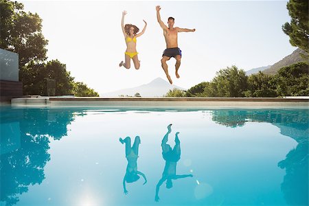 simsearch:400-07181052,k - Full length of a cheerful young couple jumping into swimming pool Stock Photo - Budget Royalty-Free & Subscription, Code: 400-07688292