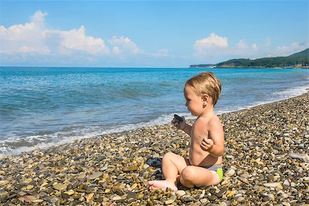 Baby boy sits in lotus pose on beach and looks at the sea Stock Photo - Budget Royalty-Free & Subscription, Code: 400-07716481