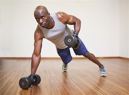 simsearch:400-04128723,k - Full length of a muscular man doing push ups with dumbbells in gym Photographie de stock - Aubaine LD & Abonnement, Code: 400-07723028