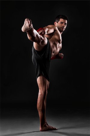 simsearch:400-05908874,k - Portrait of a muscular man practicing body combat against a dark background Stock Photo - Budget Royalty-Free & Subscription, Code: 400-07747981