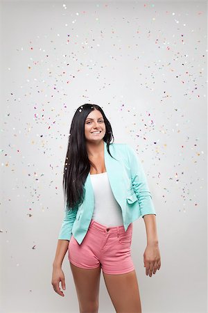Young beautiful woman in party mood with confetti all around Stock Photo - Budget Royalty-Free & Subscription, Code: 400-07748140