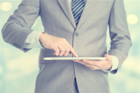 Close-up of male hands touching digital tablet, formal businessman standing with blur background. Stock Photo - Budget Royalty-Free & Subscription, Code: 400-07748795