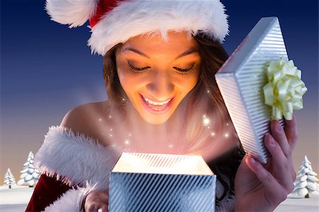 Sexy santa girl opening gift against snowy landscape with fir trees Stock Photo - Budget Royalty-Free & Subscription, Code: 400-07755443