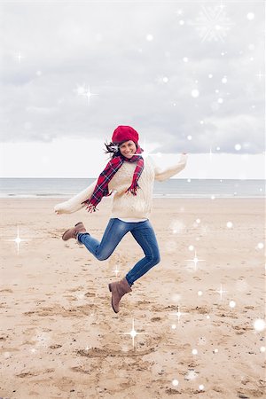 simsearch:400-07181052,k - Woman in stylish warm clothing jumping at beach against snow falling Stock Photo - Budget Royalty-Free & Subscription, Code: 400-07755849