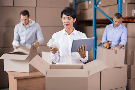 Warehouse workers packing up boxes in a large warehouse Stock Photo - Budget Royalty-Free & Subscription, Code: 400-07750254