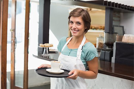 simsearch:400-07750853,k - Pretty barista smiling at camera holding tray at the coffee shop Stock Photo - Budget Royalty-Free & Subscription, Code: 400-07750844