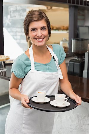 simsearch:400-07750853,k - Pretty barista smiling at camera holding tray at the coffee shop Stock Photo - Budget Royalty-Free & Subscription, Code: 400-07750843