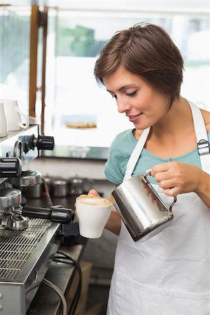simsearch:400-07750853,k - Pretty barista pouring milk into cup of coffee at the coffee shop Stock Photo - Budget Royalty-Free & Subscription, Code: 400-07750864