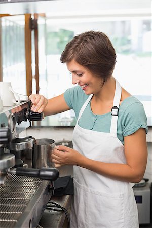 simsearch:400-07750853,k - Pretty barista steaming jug of milk at coffee machine at the coffee shop Stock Photo - Budget Royalty-Free & Subscription, Code: 400-07750865