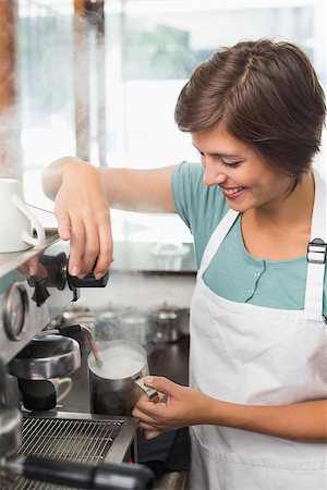 simsearch:400-07750853,k - Pretty barista steaming jug of milk at coffee machine at the coffee shop Stock Photo - Budget Royalty-Free & Subscription, Code: 400-07750869