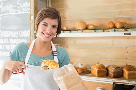 simsearch:400-07750853,k - Pretty waitress picking up croissant at the coffee shop Stock Photo - Budget Royalty-Free & Subscription, Code: 400-07750886