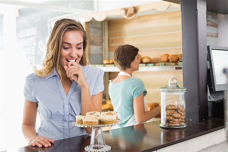 simsearch:400-07750853,k - Pretty blonde being tempted by cupcakes at the coffee shop Stock Photo - Budget Royalty-Free & Subscription, Code: 400-07750882