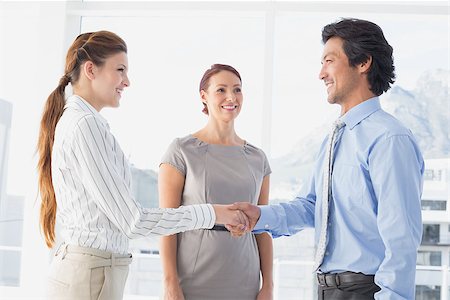 Business man shaking colleagues hand while smiling Stock Photo - Budget Royalty-Free & Subscription, Code: 400-07751809