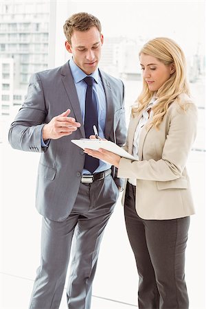 Young businessman and his secretary looking at diary in office Stock Photo - Budget Royalty-Free & Subscription, Code: 400-07777797