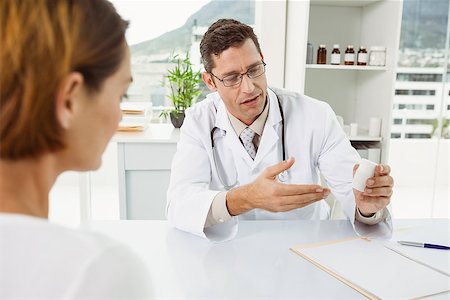 doctor giving medicine to adult patient - Male doctor giving a prescription to patient in his medical office Stock Photo - Budget Royalty-Free & Subscription, Code: 400-07778467