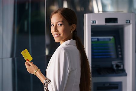 simsearch:400-06858518,k - Portrait of latina businesswoman withdrawing dollar from atm cash machine and showing credit card to camera Stock Photo - Budget Royalty-Free & Subscription, Code: 400-07771844