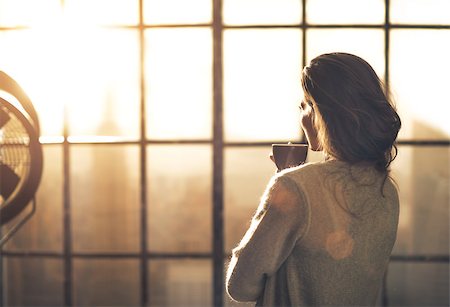 Young woman enjoying cup of coffee in loft apartment. rear view Stock Photo - Budget Royalty-Free & Subscription, Code: 400-07797269