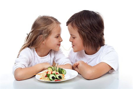 Kids sipping on the same string of pasta - sharing a plate of healthy food, isolated Stock Photo - Budget Royalty-Free & Subscription, Code: 400-07793726