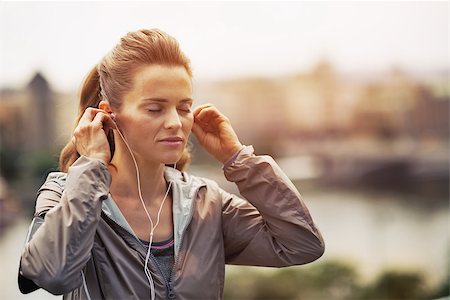 female wearing trainers - Portrait of fitness young woman wearing earphones in city in the evening Stock Photo - Budget Royalty-Free & Subscription, Code: 400-07793969