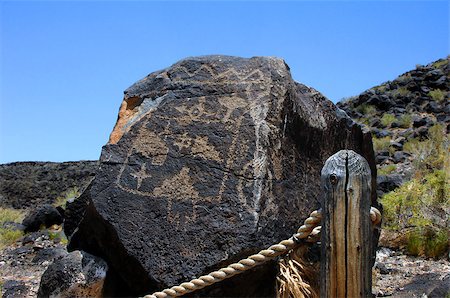 Large basalt rock has Pueblo Indian petroglyph.  Roped trail leads through one of the trail options in the Petroglyph National Monument in Albuquerque, New Mexico. Stock Photo - Budget Royalty-Free & Subscription, Code: 400-07824290