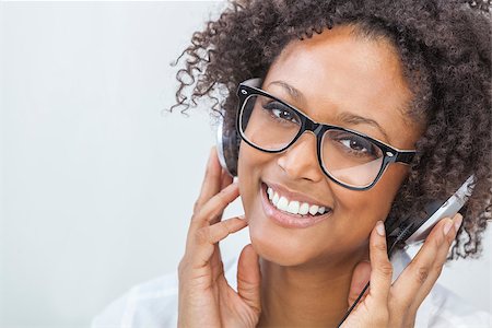 simsearch:400-06422339,k - A beautiful mixed race African American girl or young woman wearing glasses and listening to music on mp3 player and headphones Foto de stock - Super Valor sin royalties y Suscripción, Código: 400-07820956