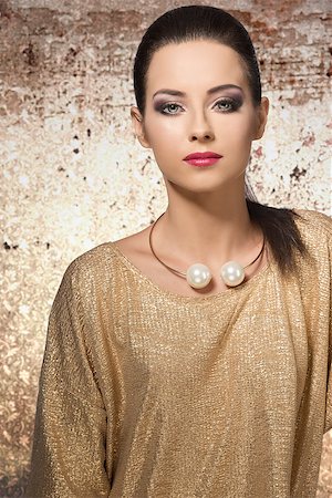 very pretty female with long brown hair wearing elegant golden dress, posing with stylish make-up and big trendy necklace. Stock Photo - Budget Royalty-Free & Subscription, Code: 400-07822211